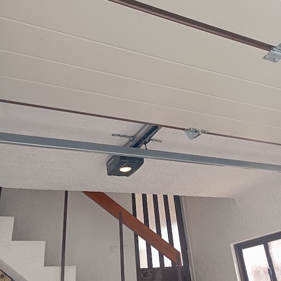 Motor e calha de acionamento de uma porta seccionada de garagem